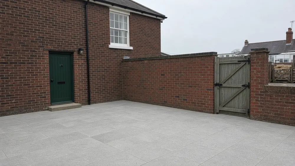Example image: grey porcelain patio in a walled yard behind a Victorian terraced house near the sea